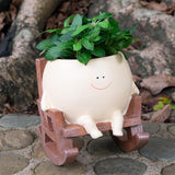 Pot de fleurs à visage souriant