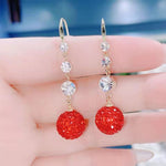 Boucles d'oreilles élégantes longues boules rouges pleines de diamants